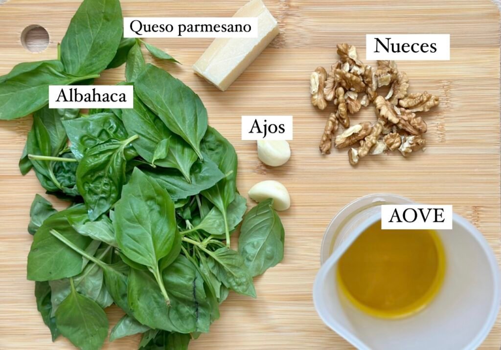 Ingredientes necesarios para preparar pesto casero con nueces. Hojas de albahaca, aceite de oliva virgen extra, ajos, nueces y queso parmesano.