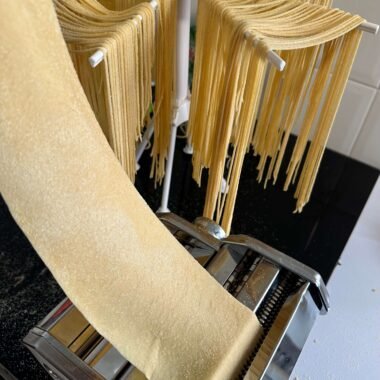 Pasando masa de pasta por la máquina para hacer pasta