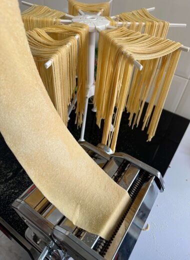 Pasando masa de pasta por la máquina para hacer pasta