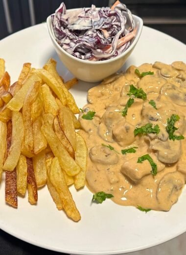 Chicken with mushrooms and cream served with fries and coleslaw