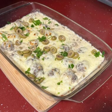 gratin meatballs in cream sauce with olives and cheese