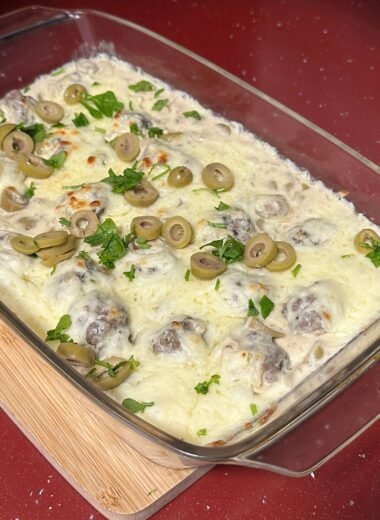 gratin meatballs in cream sauce with olives and cheese