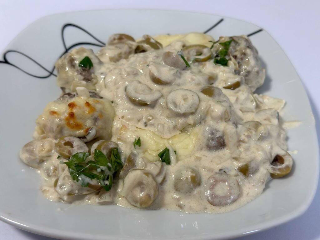 Plate of meatballs with olives in cream sauce