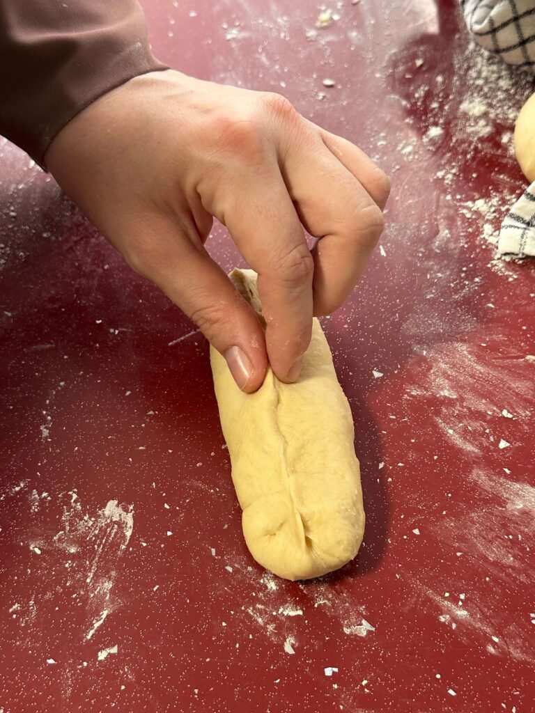 Closing the dough to make hot dog buns