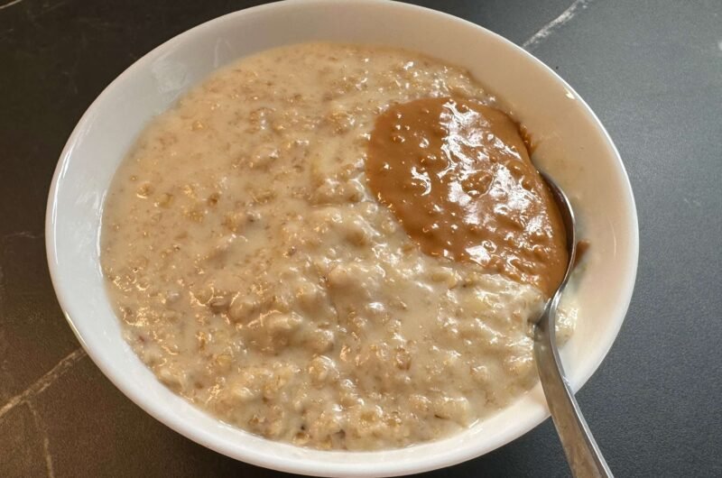 bowl de avena endulzada con banana con una cucharada de crema de cacahuetes crujiente