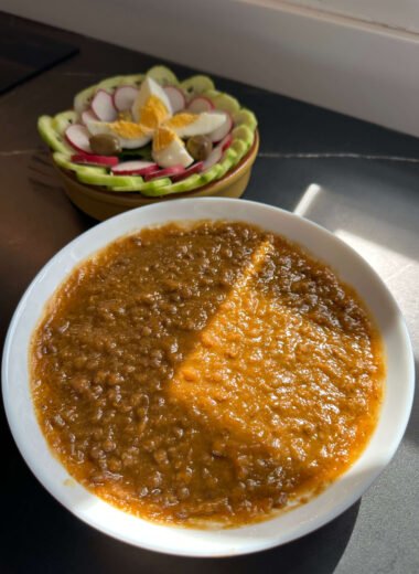 Plato de lentejas con verduras trituradas y un plato de ensalada